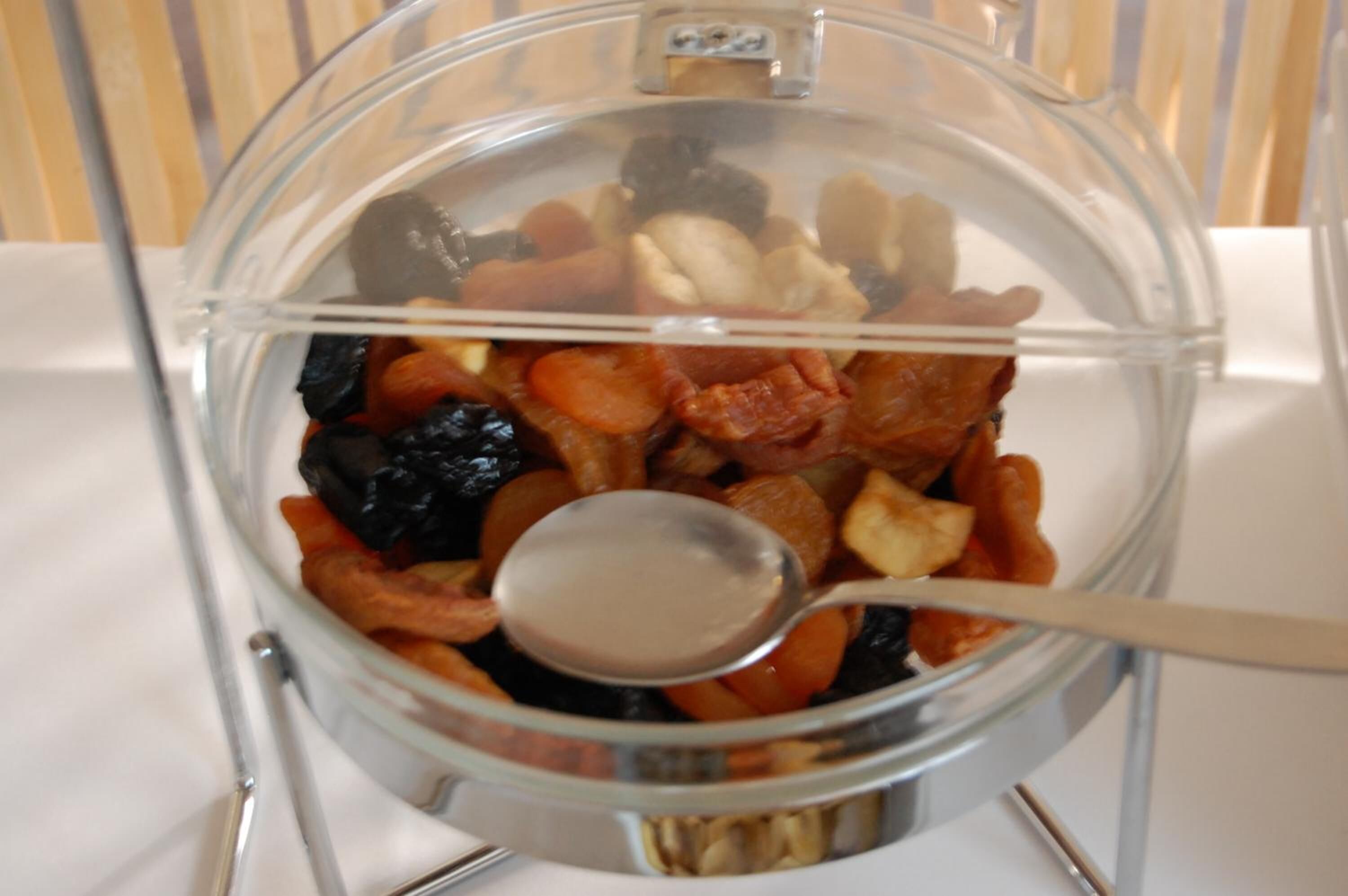 A food processor filled with various nuts and dried fruits.