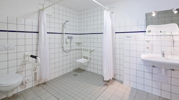 Een badkamer met douche, toilet en wastafel.