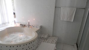 A bathroom with a large bathtub, a shower, and a tiled floor. - iLanga Lodge (St. Lucia)