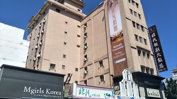 A hotel with multiple floors, air conditioning units, and a prominent sign for 'Hotel'. - Unique Holiday Hotel (Hualien City)