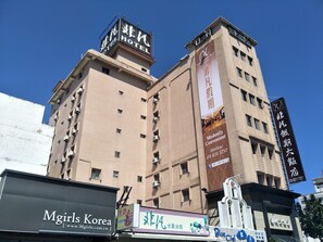 A hotel with multiple floors, air conditioning units, and a prominent sign for 'Hotel'. - Unique Holiday Hotel (Hualien City)
