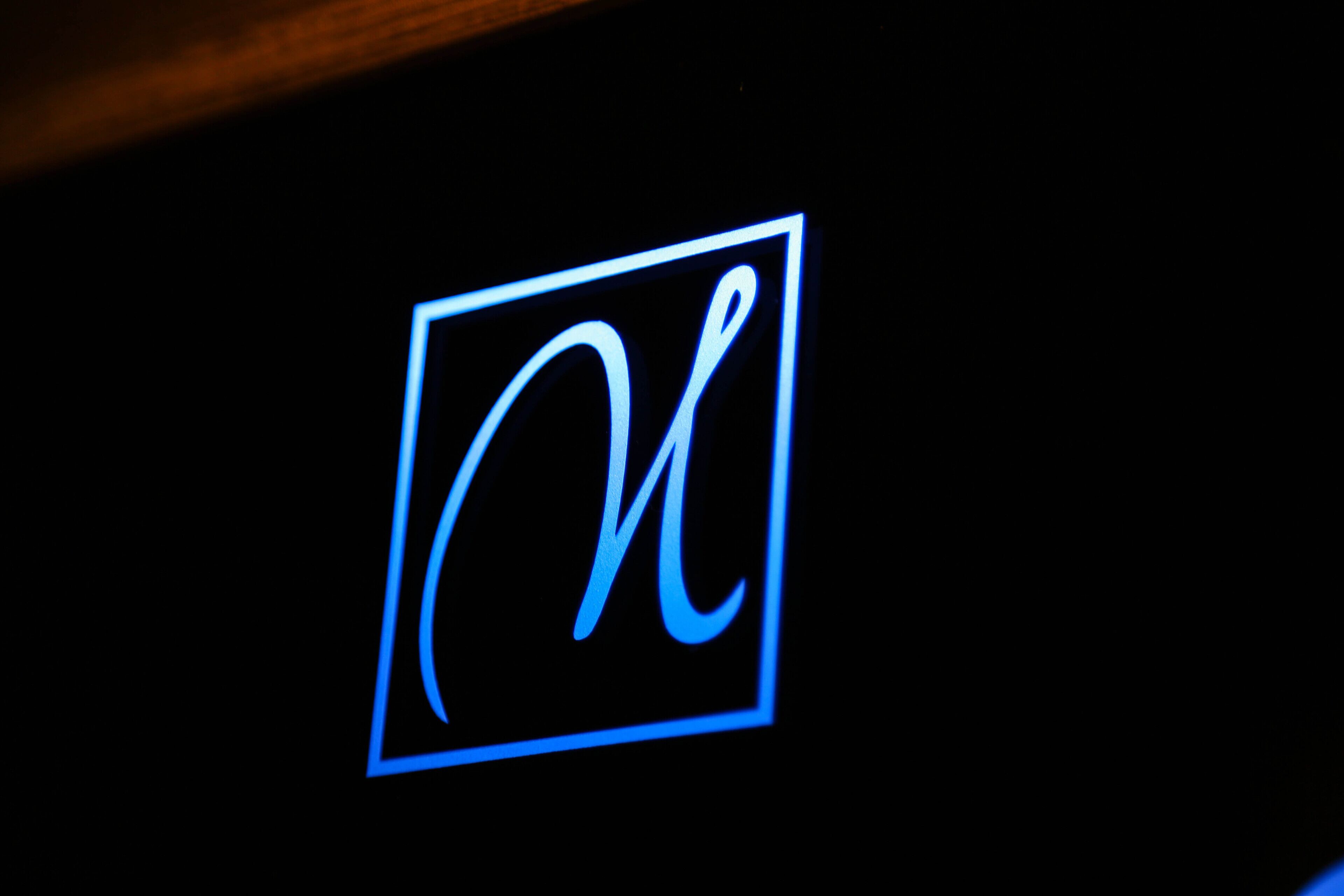 A neon sign with a stylized letter 'N' in a square frame.
