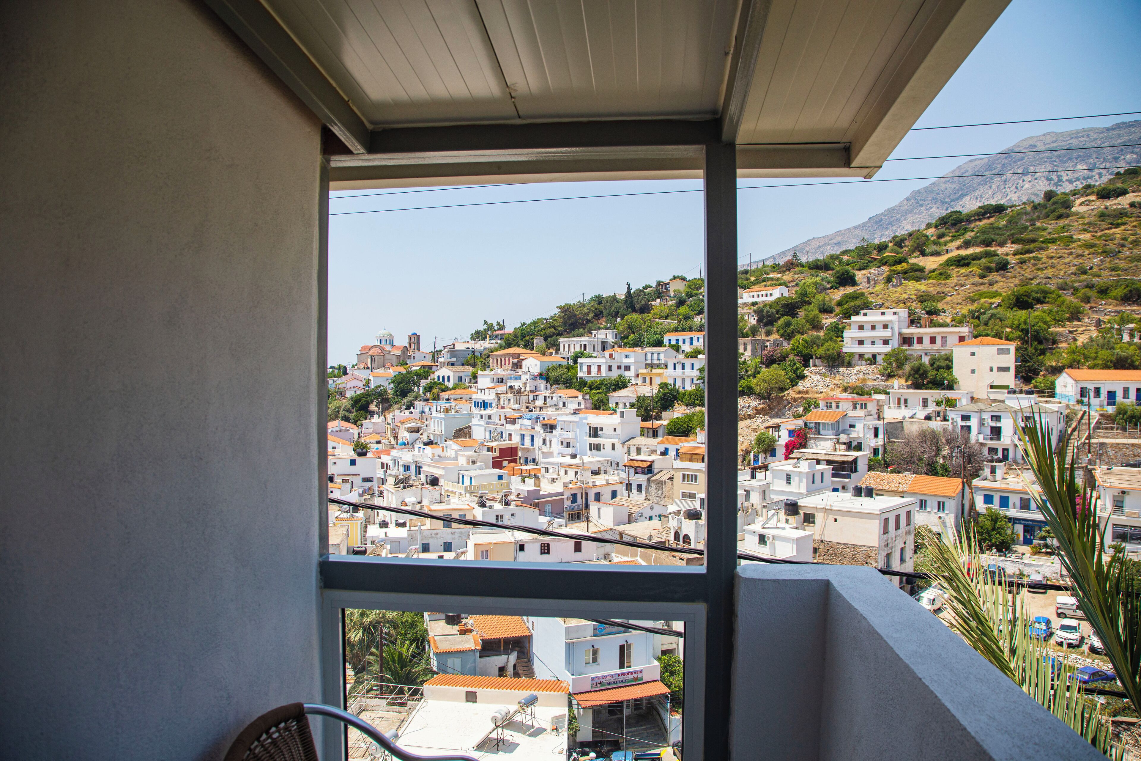 Varanda com vista para uma cidade em declive, com construções bem próximas umas das outras.