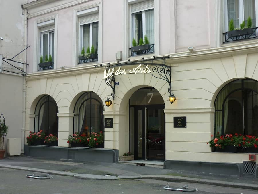 Fachada de hotel de estilo arquitectónico clásico, con ventanas arqueadas y una entrada destacada.