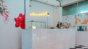 A reception area with a marble counter, a neon sign, and a check-in station. - Side Walk Boutique Hotel (Rayong)