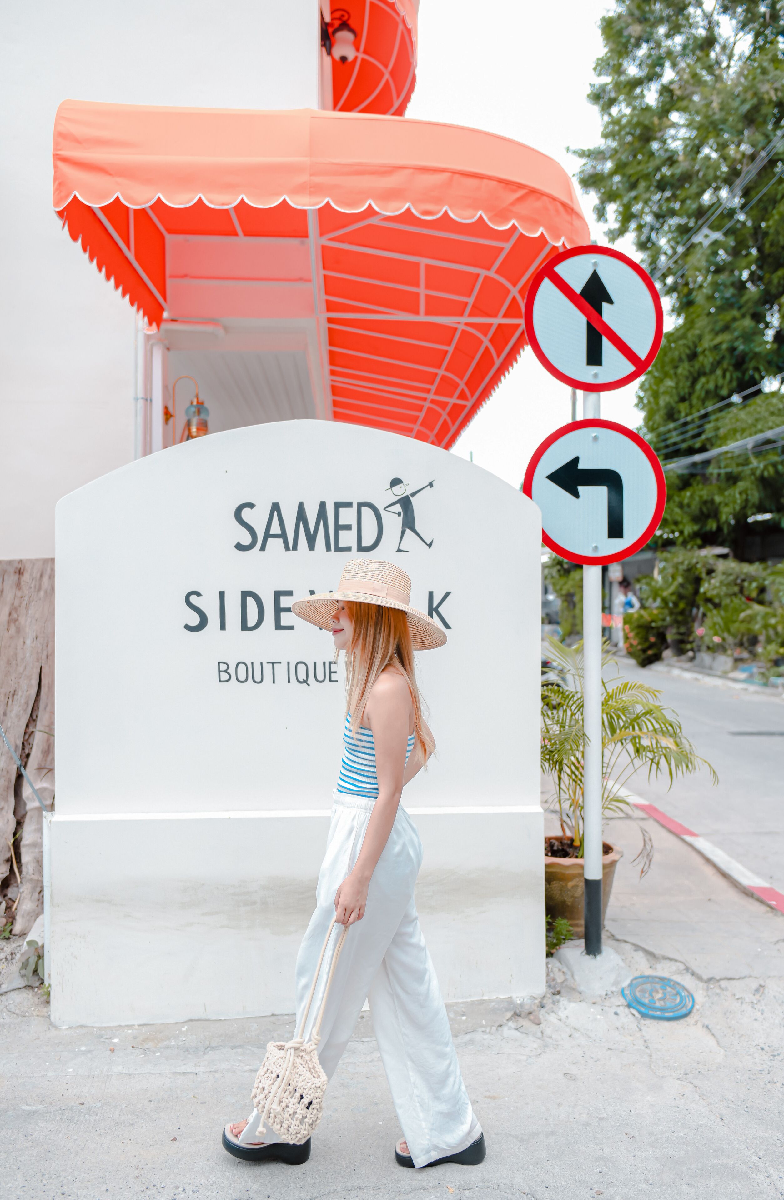 A sign for 'Samed Sidek Boutique' with directional arrows and a no entry sign.