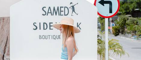 A sign for 'Samed Sidek Boutique' with directional arrows and a no entry sign.