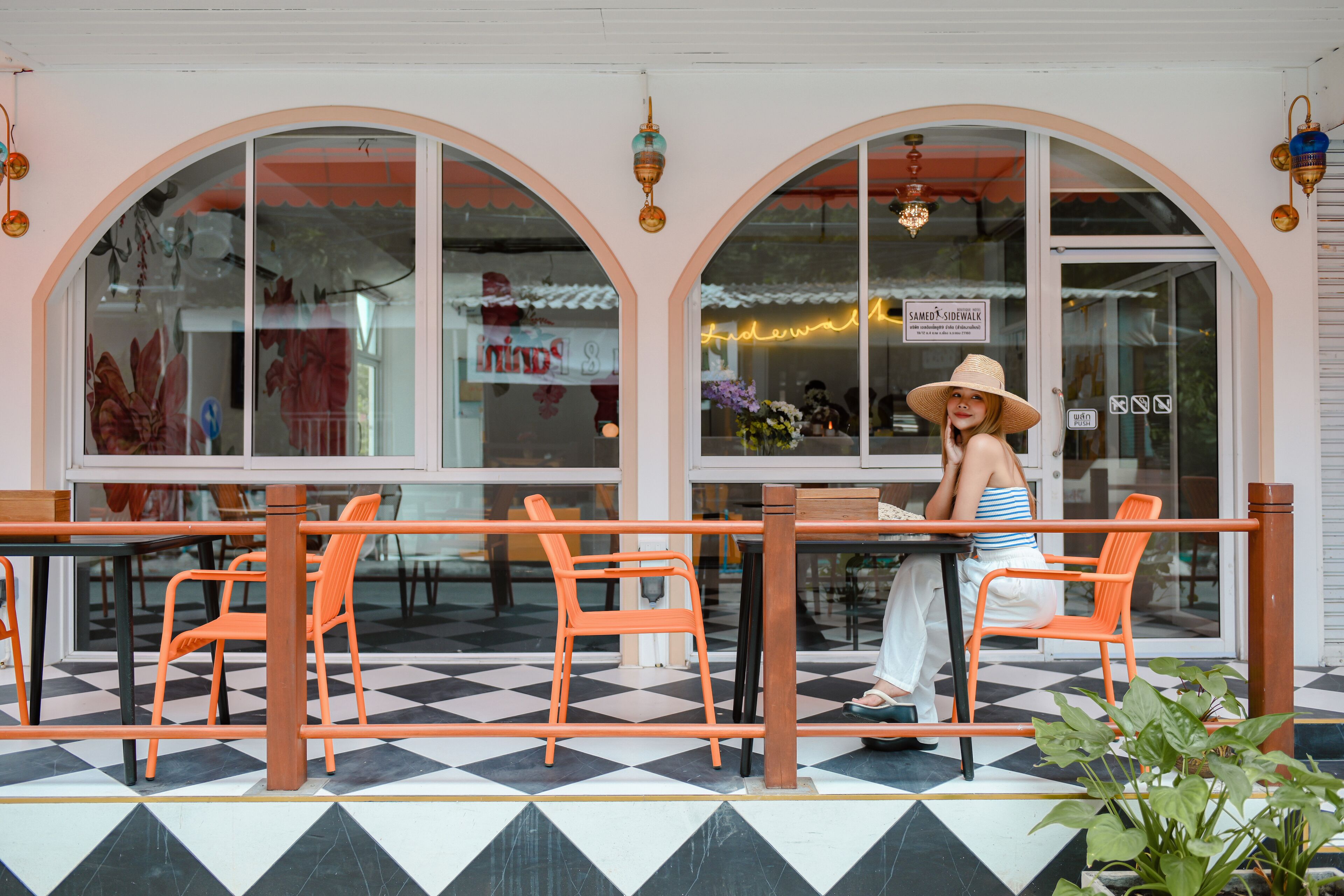 An outdoor seating area with orange chairs and a checkered floor.