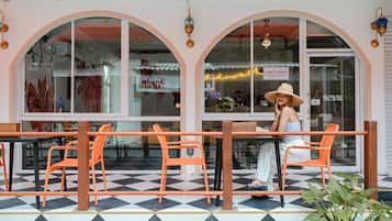 An outdoor seating area with orange chairs and a checkered floor.