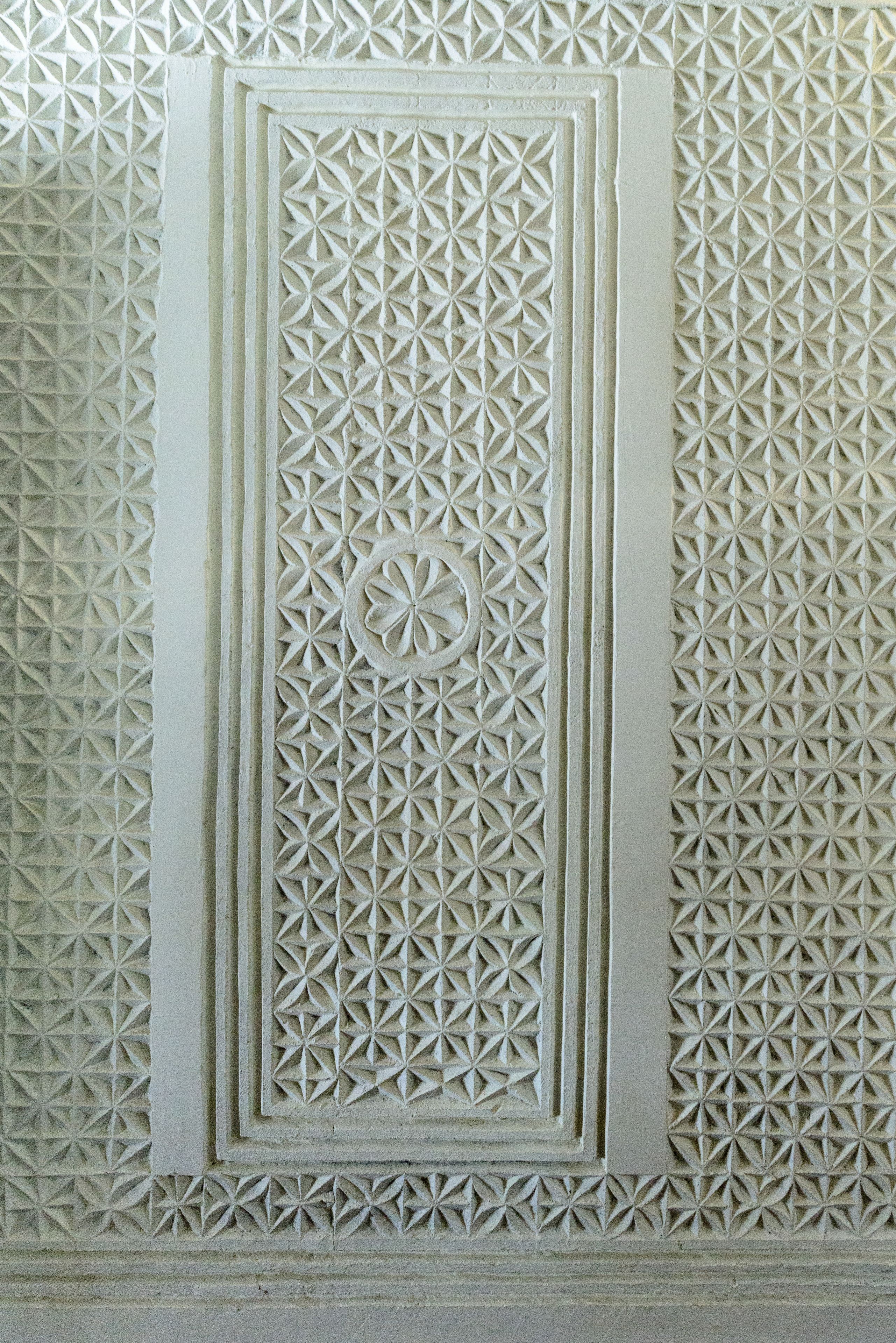 A detailed architectural carving with geometric patterns and a central circular motif.