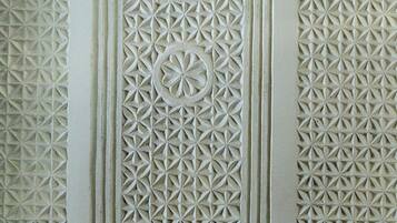 A detailed architectural carving with geometric patterns and a central circular motif.