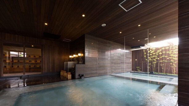 A modern indoor swimming pool with wooden paneling and a glass wall. - Hotel Kikyou (Kaga)