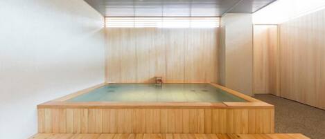 A wooden sauna with a rectangular shape and a raised platform.