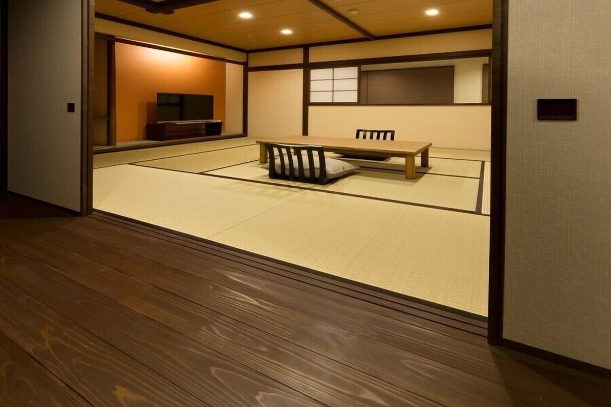 A traditional Japanese room with tatami flooring, a low wooden table, and sliding doors.