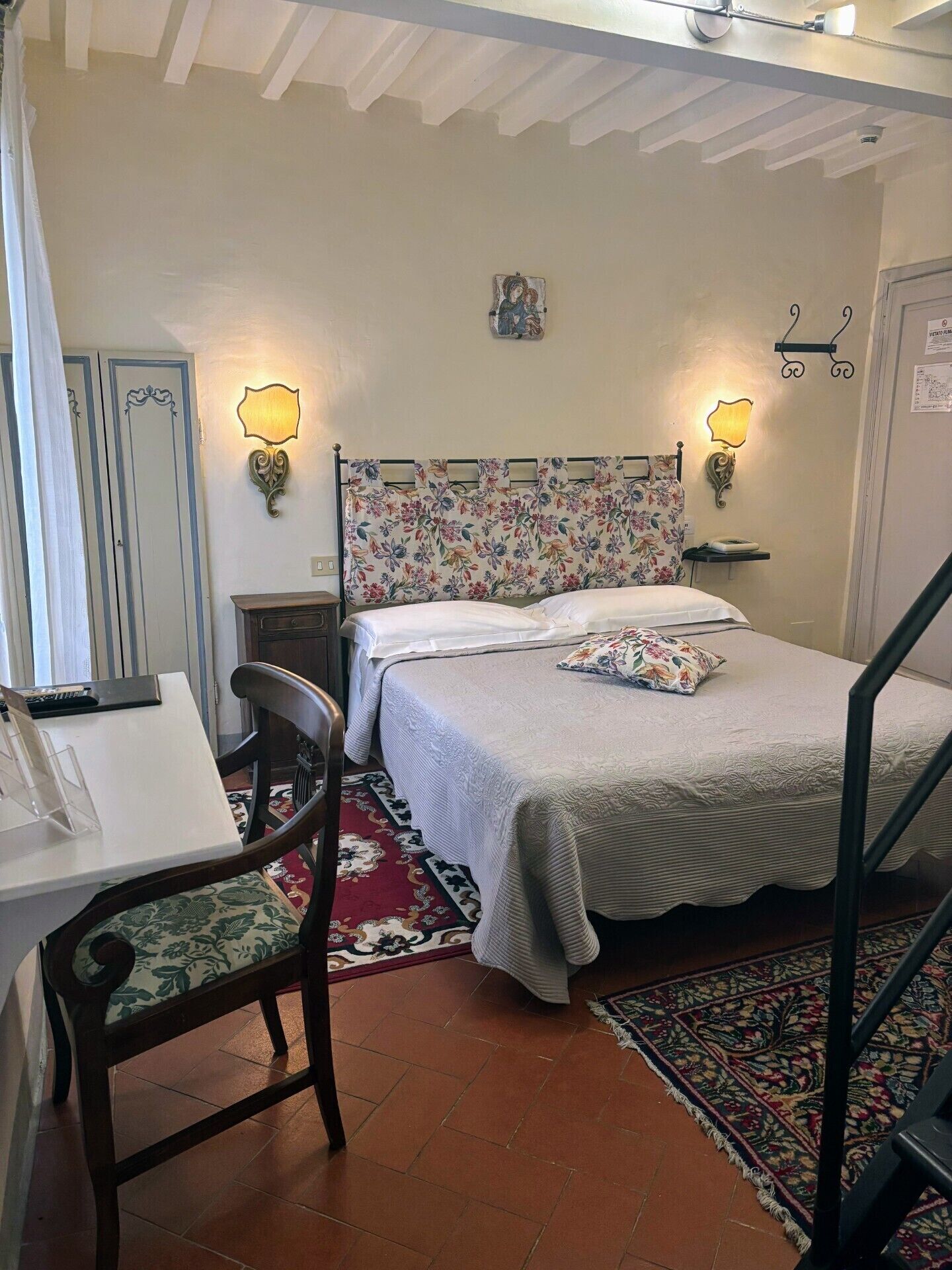 Une chambre à coucher avec un lit, un bureau, une chaise et un escalier.
