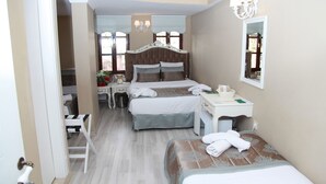 Una habitación de hotel con dos camas, un escritorio, una silla, un tocador y un espejo.