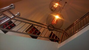 Un escalier doté d’une rampe métallique et d’un luminaire décoratif composé de deux éléments sphériques.