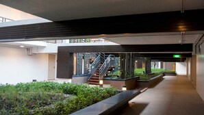 A modern indoor space with a staircase, planters, and a clean, minimalist design. - Impact Novo Condo Muang Thong Thani (Pak Kret)