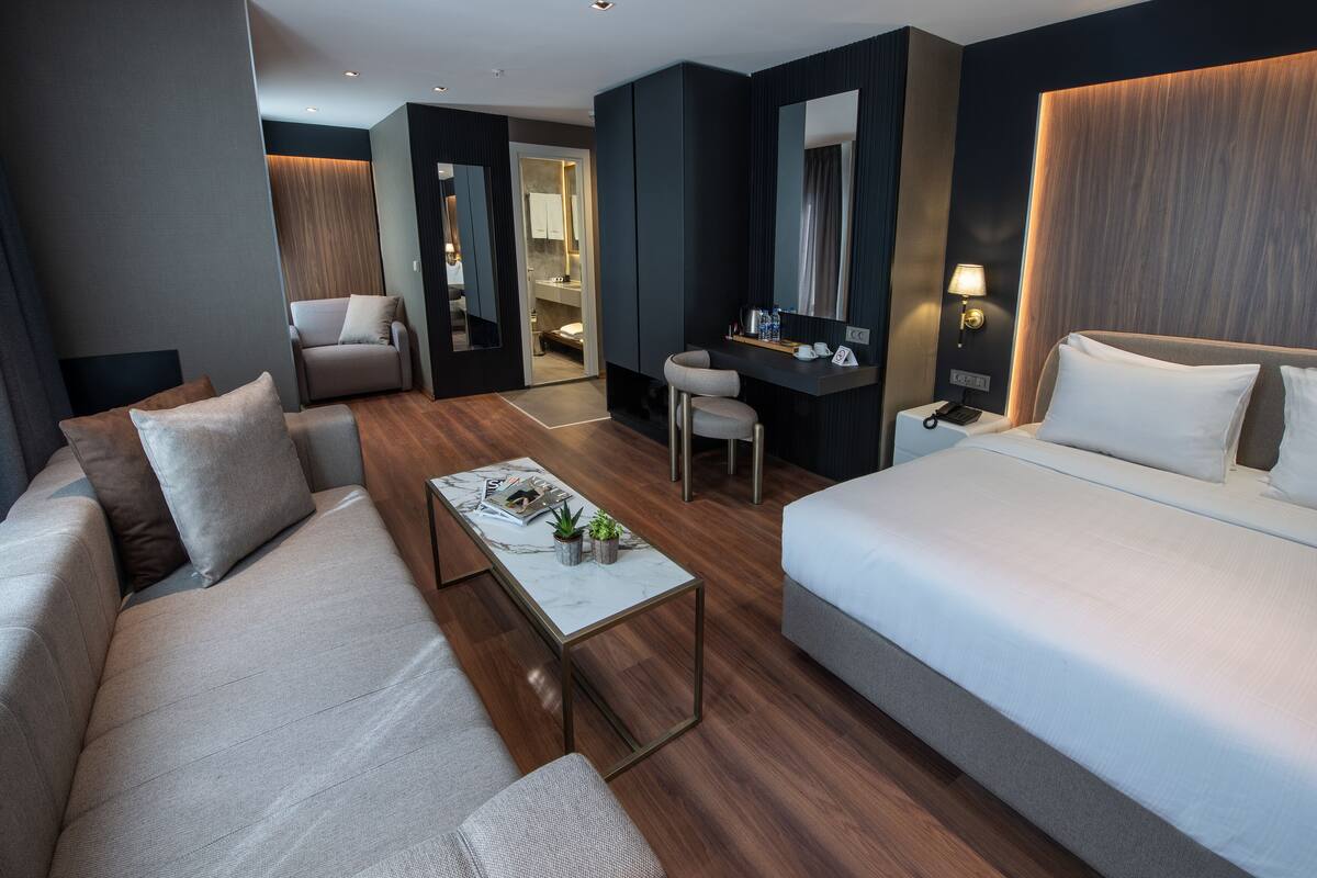 Une chambre d’hôtel moderne équipée d’un canapé, d’un lit, d’un bureau et d’une chaise.