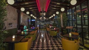 A restaurant with a checkered floor, wooden ceiling with hanging lights, and green and yellow chairs. - Hotel Bosfora (Istanbul)