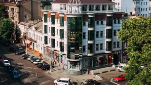 A multi-story hotel with a prominent glass facade, a dome on top, and a visible restaurant sign.