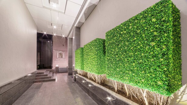 A hallway with a green wall and steps leading to a door with a sign.