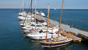 A marina with multiple sailboats docked at a pier.