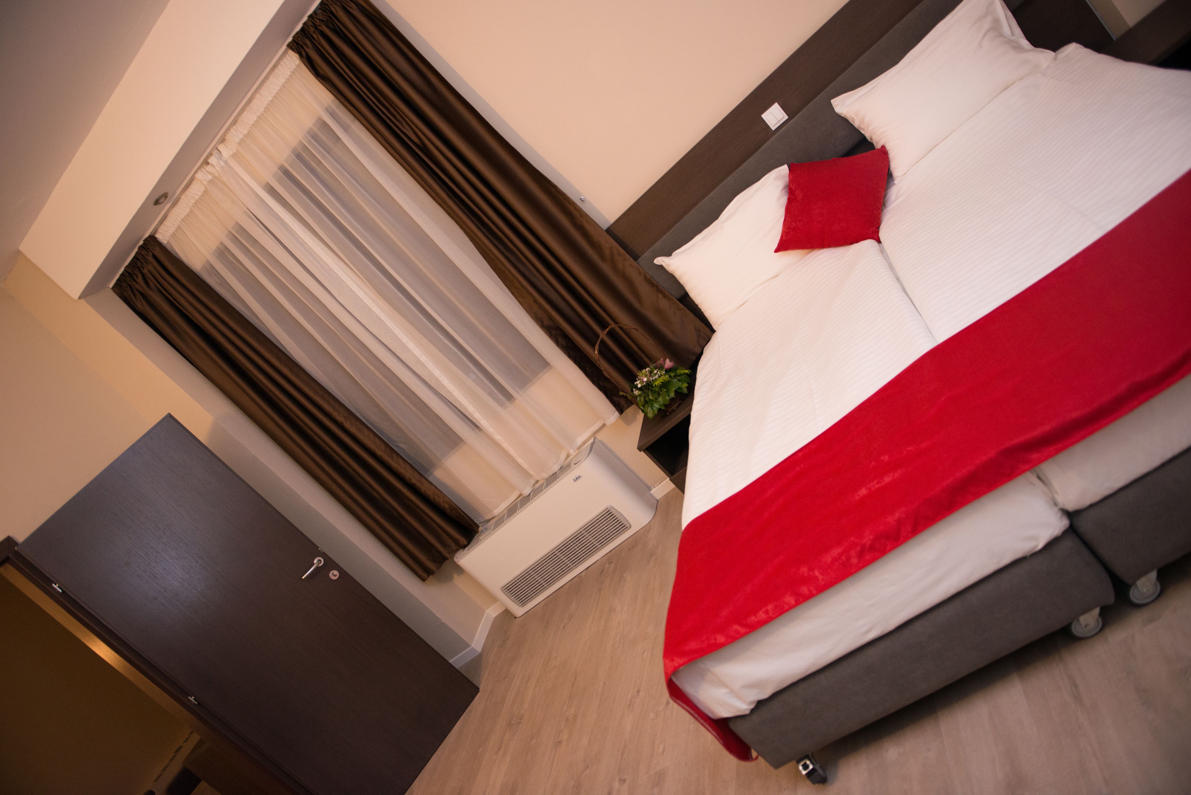 Una habitación de hotel con cama, armario y aire acondicionado.