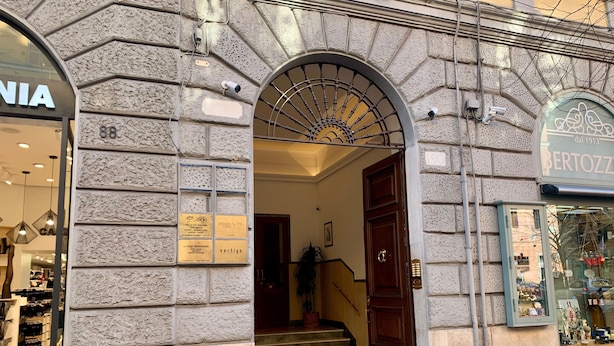 A building entrance with a stone facade, a wooden door, and a staircase leading inside. - Bed and Best (Rome)