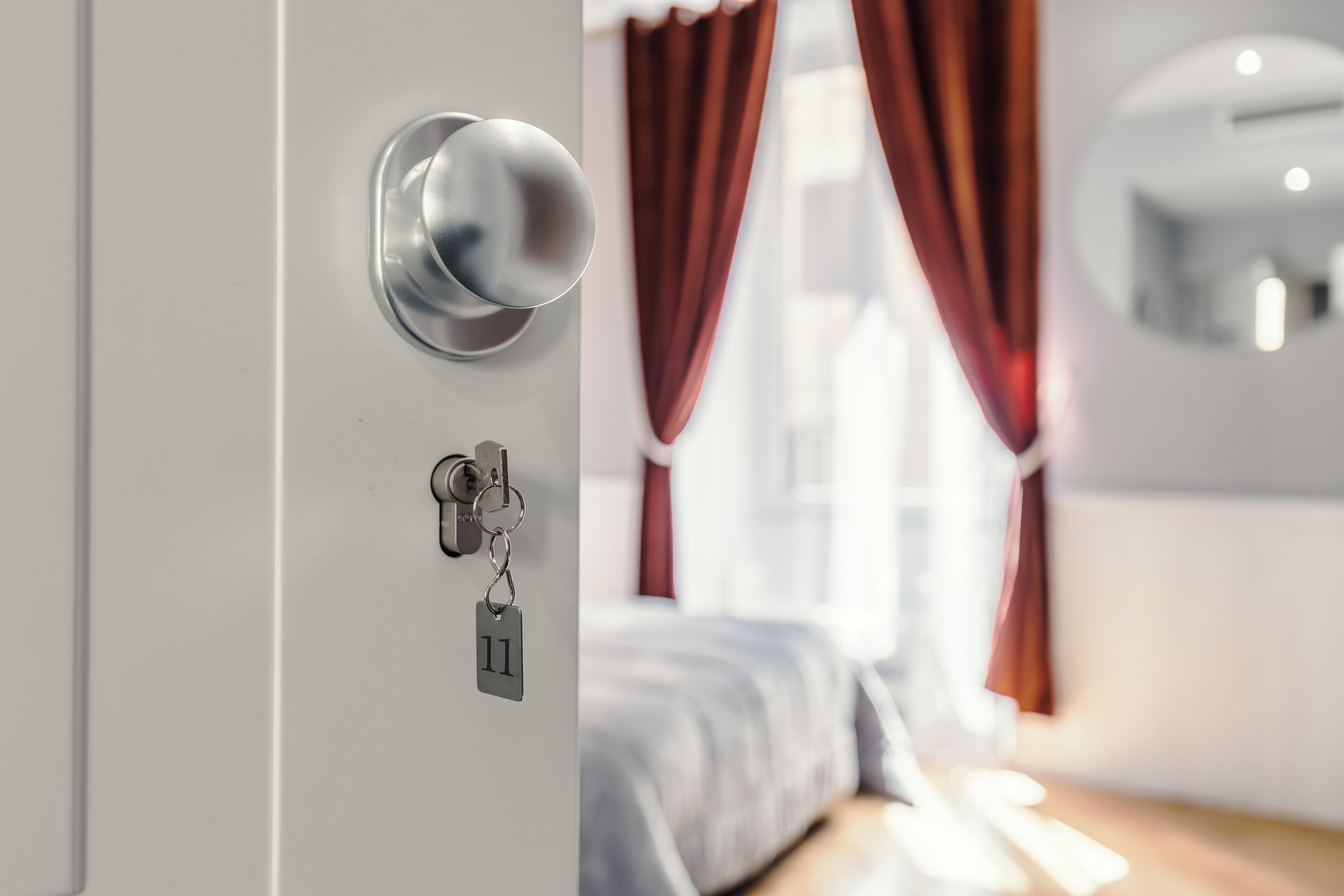 Eine Hotelzimmertür mit Schlüsselloch und Schlüsselanhänger mit einer Nummernaufschrift.