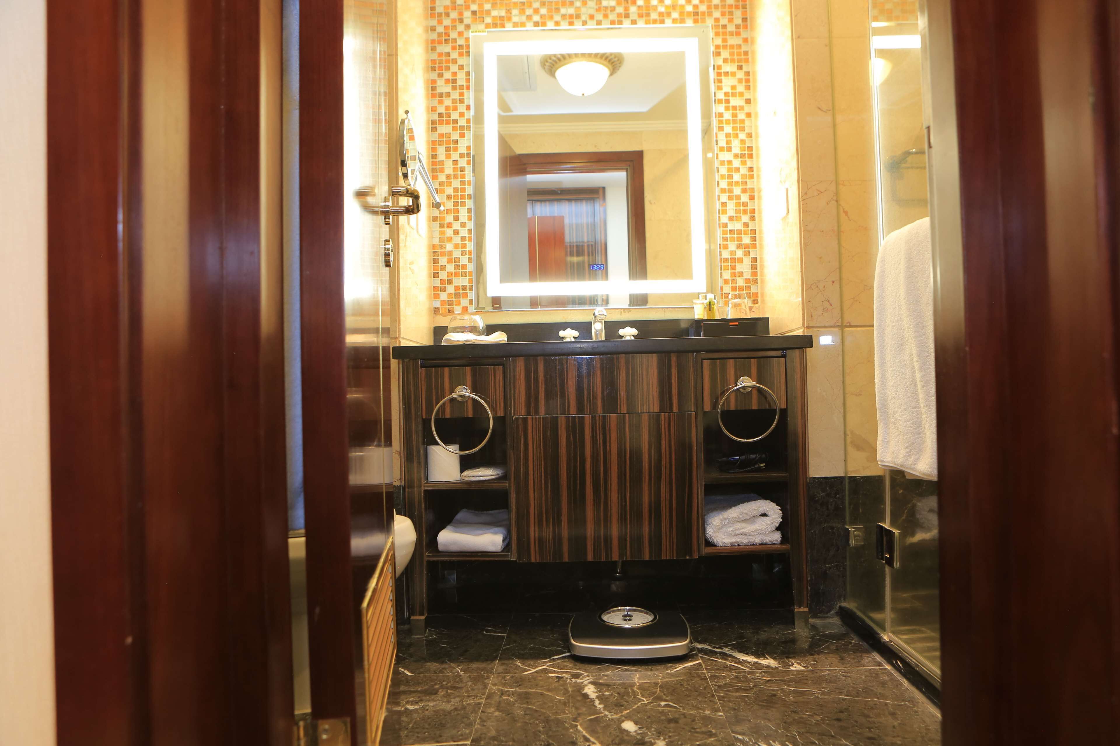 Ein Badezimmer mit einer Waage, zwei Waschbecken und einem Spiegel über der Ablagefläche.