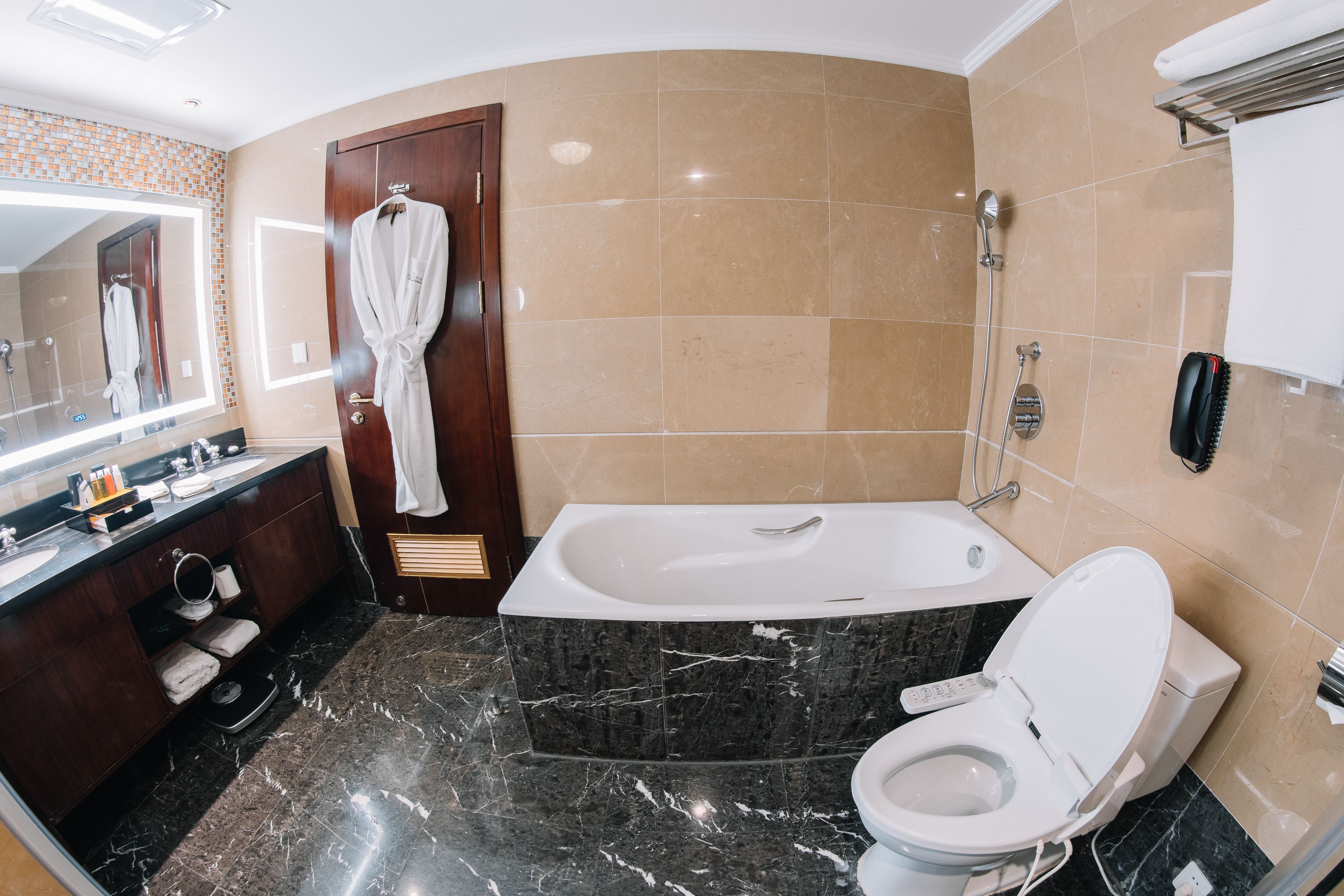 A modern bathroom with a bathtub, toilet, and vanity.