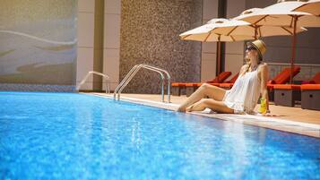 Piscine extérieure, parasols de plage, chaises longues