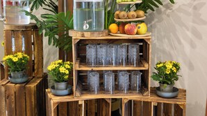 Une étagère en bois servant de présentoir, avec des récipients en verre, des plantes en pot et un tapis moelleux.