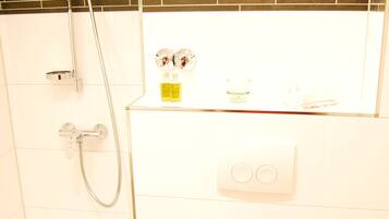 Ein Badezimmer mit Dusche, Toilette und kleinem Waschbecken.