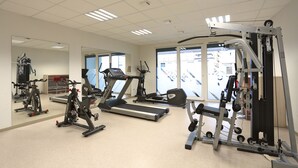 A gym with treadmills, stationary bikes, and weight machines. - Apparteo Nancy (Nancy)