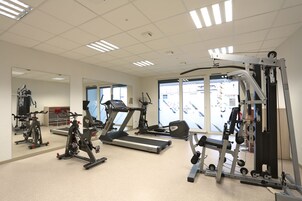 A gym with treadmills, stationary bikes, and weight machines.