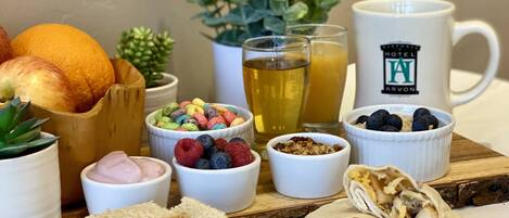 Un desayuno con diversas opciones de comida, como frutas, cereales y pasteles, dispuesto sobre una tabla de madera.