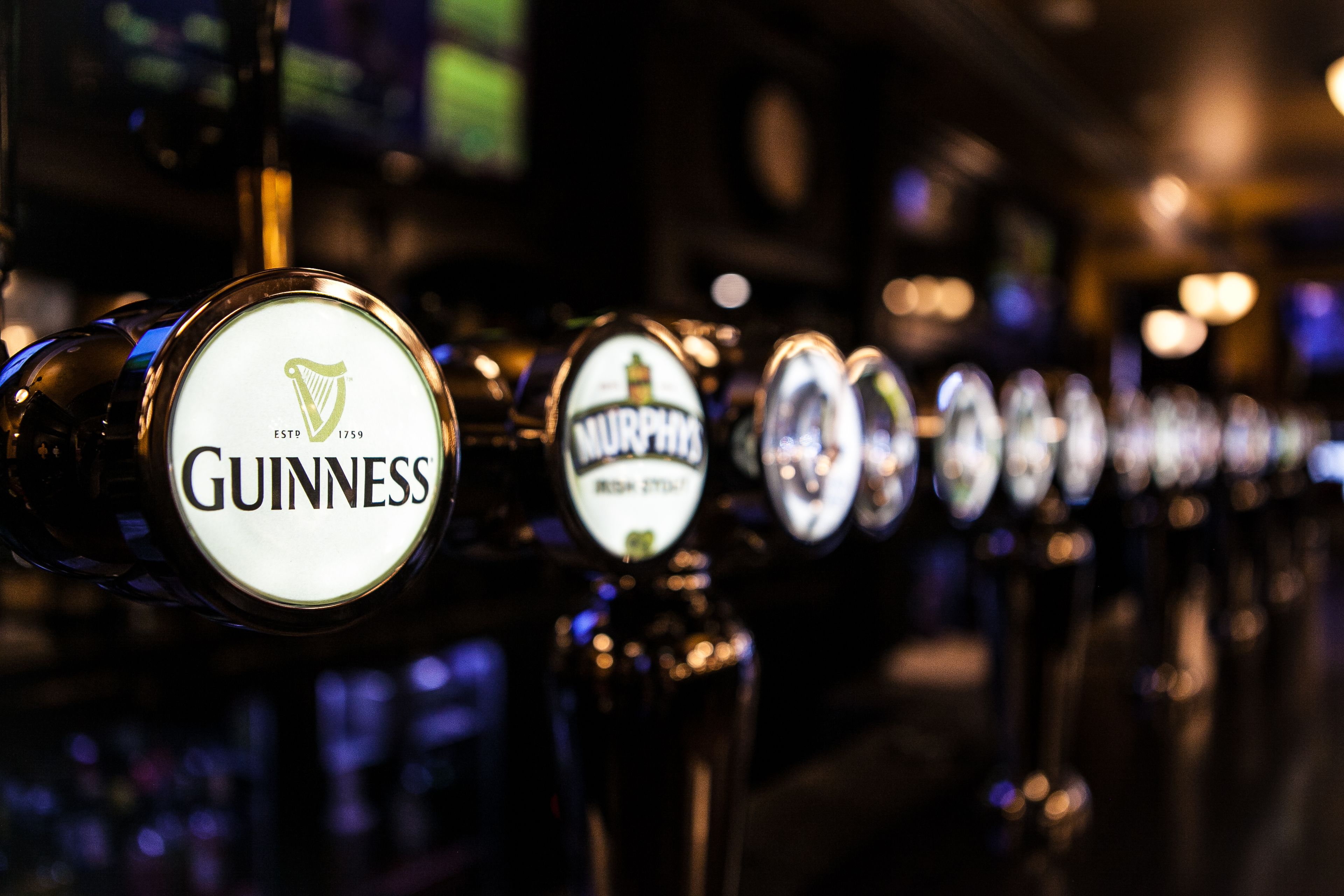 Eine Reihe von Bierhähnen mit sichtbaren Markennamen wie Guinness und Murphy's.