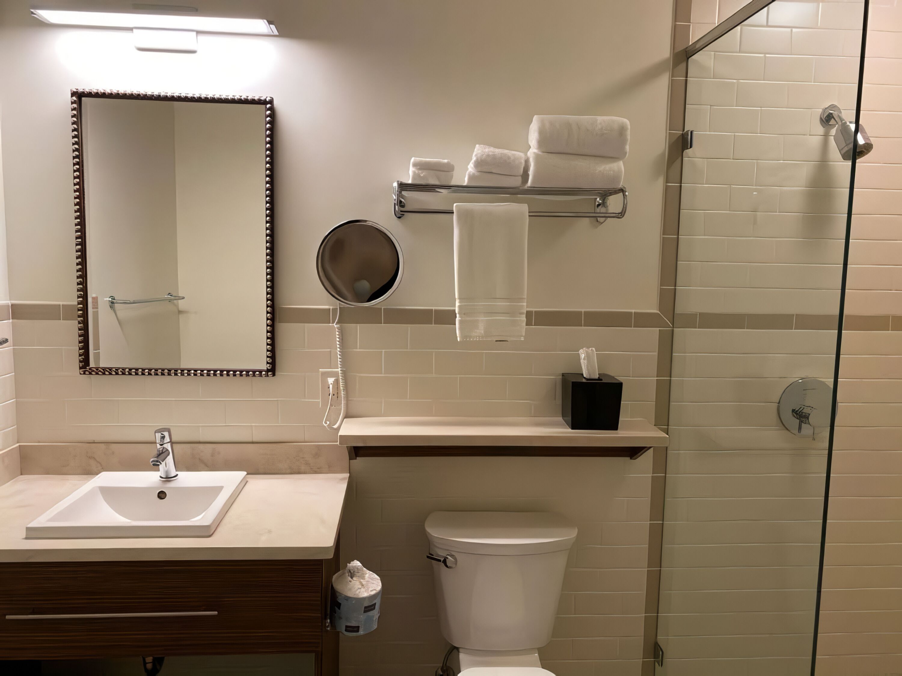 A modern bathroom with a sink, mirror, towel rack, and toilet.