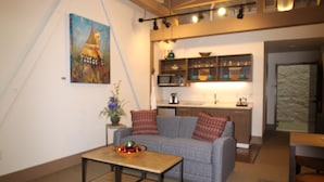 Una sala de estar moderna con un sofá, una mesa de centro y un cuadro en la pared.