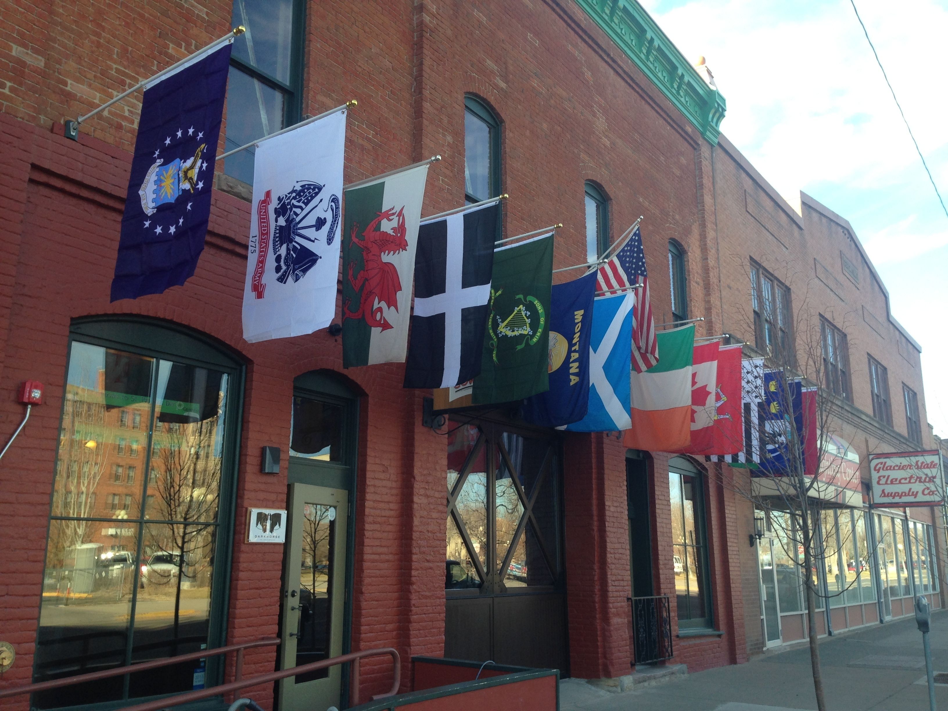 A building with multiple flags, including the United States flag, flags of Montana, and other state flags.