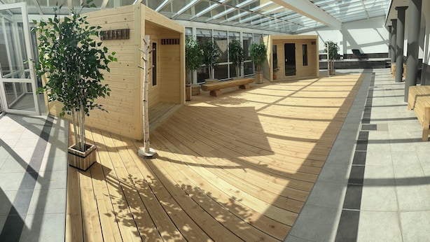 Un espace intérieur spacieux doté d’un plancher en bois, de bancs et de plantes en pot.