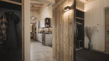 Una cocina moderna con detalles de madera, un comedor y un pasillo que lleva a un dormitorio.