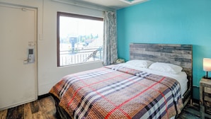 A bedroom with a bed, a window with curtains, a wooden headboard, and a nightstand with a lamp. - Hotel O Miami Inn & Suites Chicago Midway Airport (Oak Lawn)