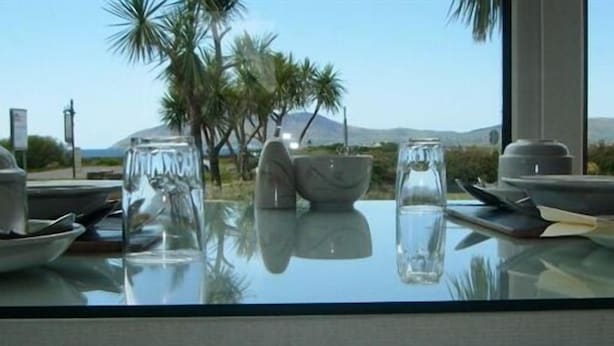 Una mesa con vistas despejadas a palmeras y una montaña al fondo.