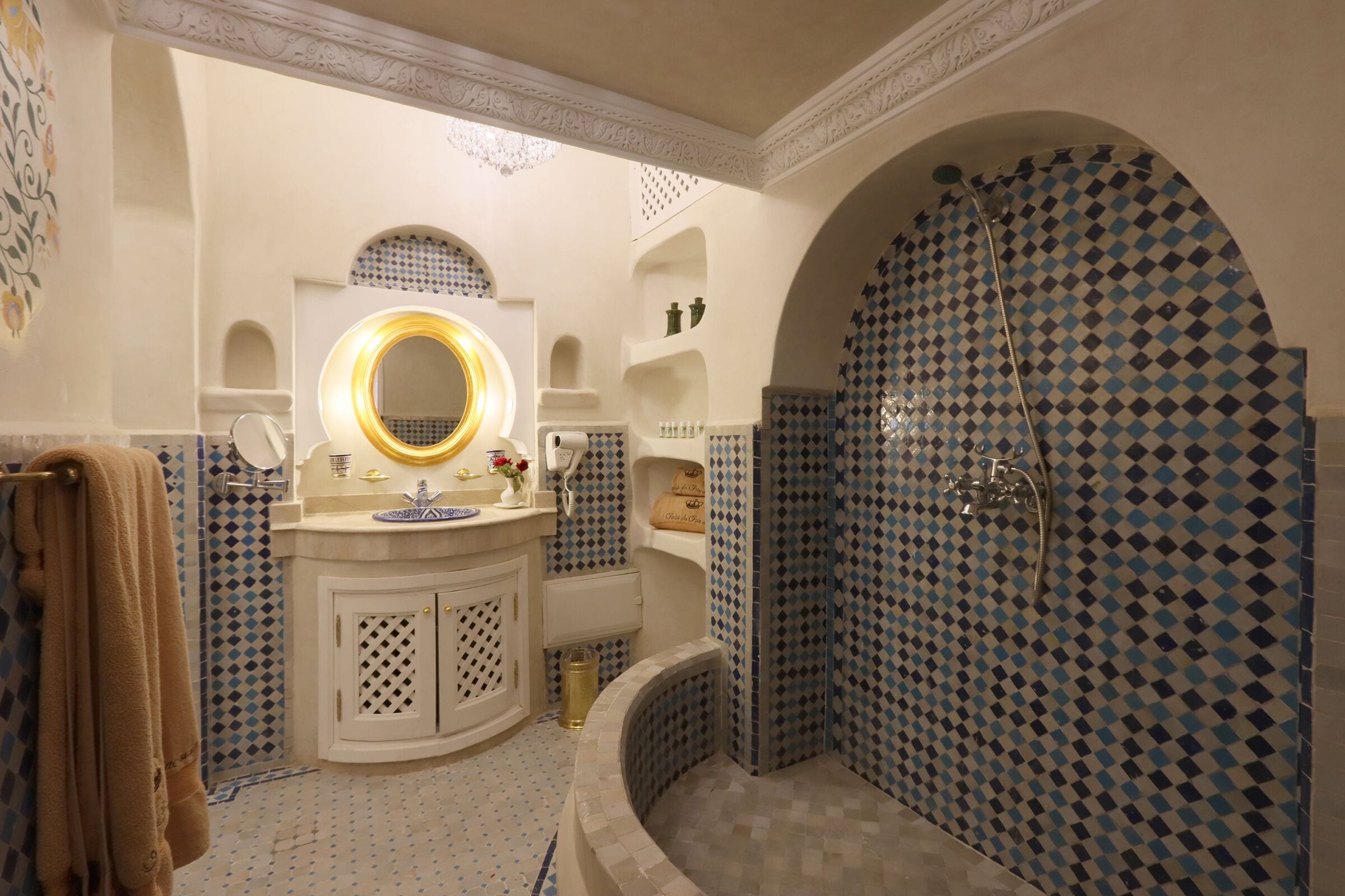 Un baño con bañera, un lavabo con espejo y una zona de ducha con pared de diseño.