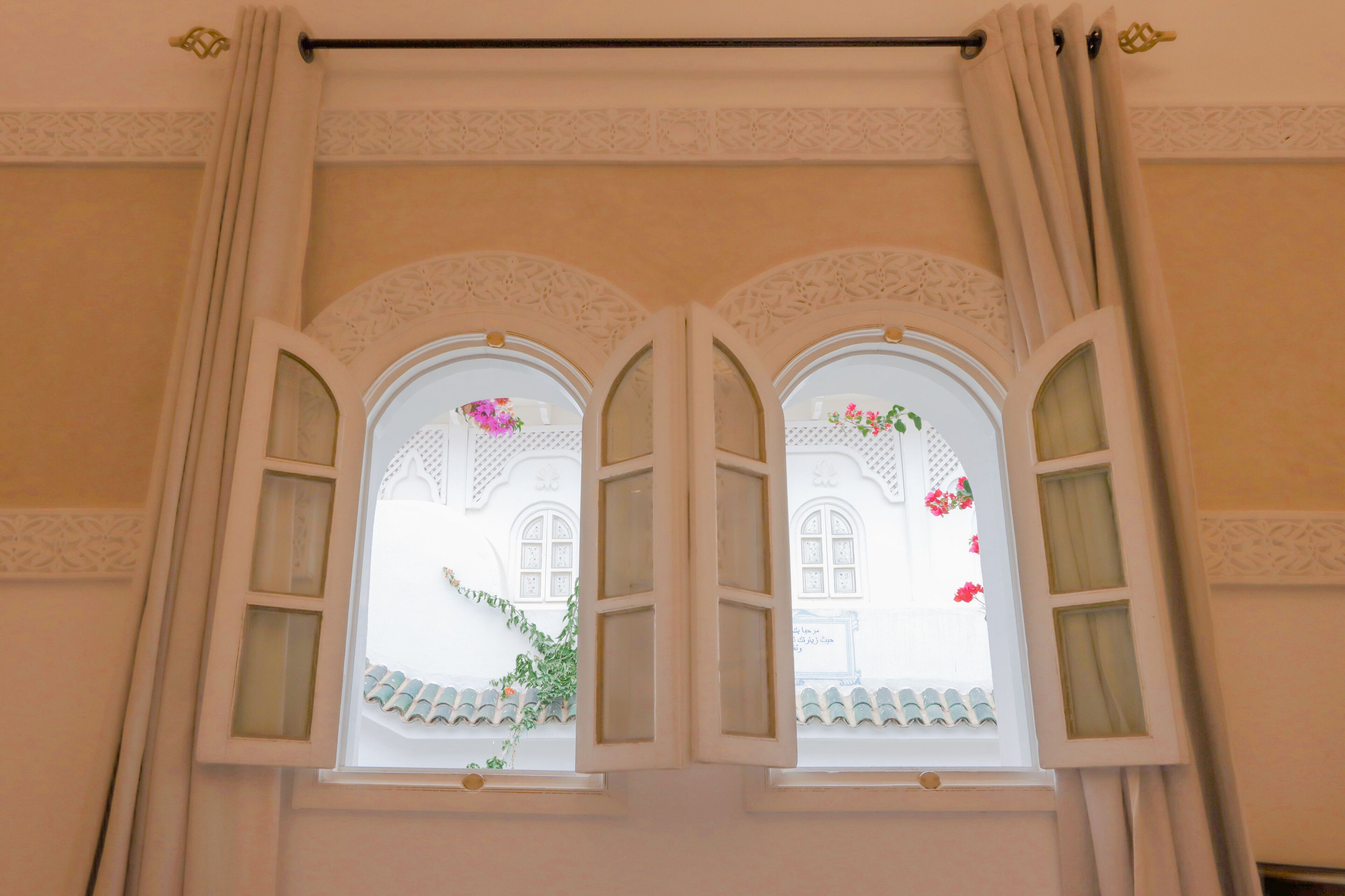 A window with two sections, each with a decorative arch and a small window.