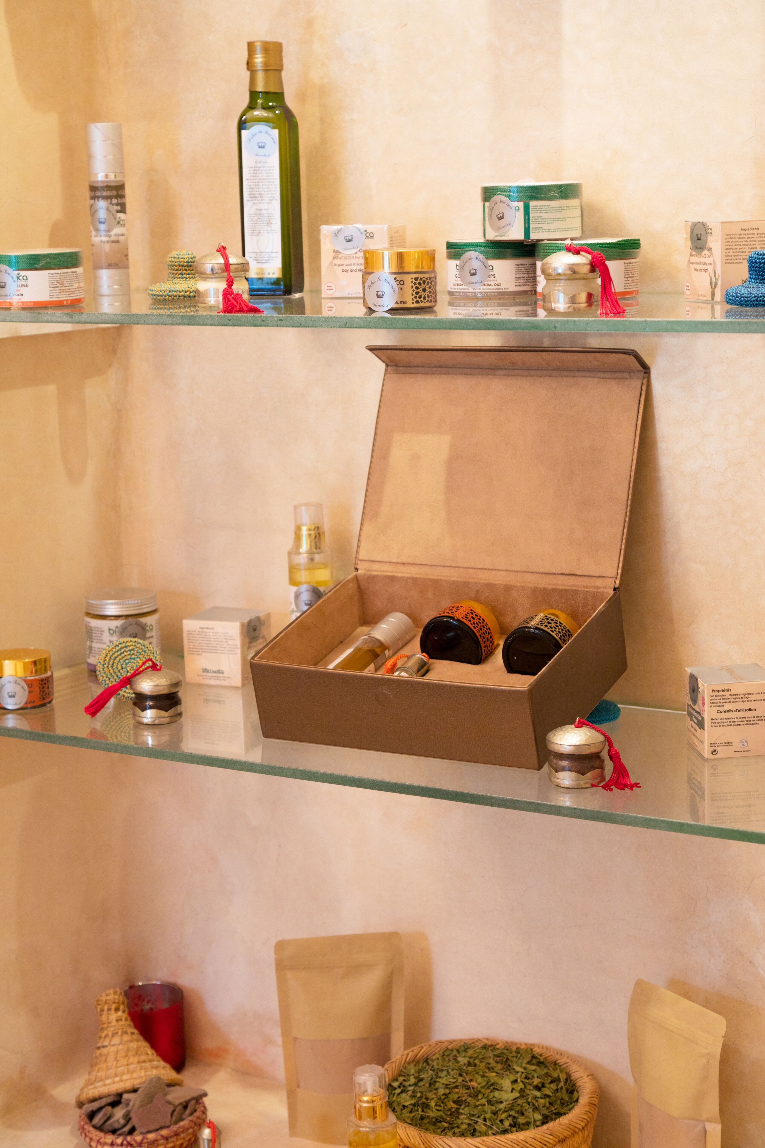 A glass display case with various toiletries and a box of candles.