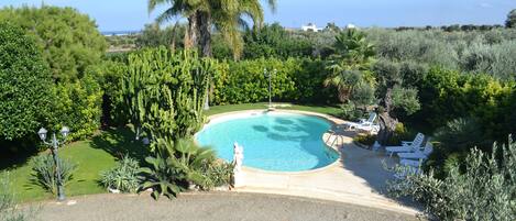 Piscine extérieure, parasols de plage, chaises longues